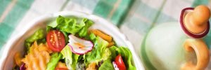 salad bowl with fresh greens and dressing dispenser on the side